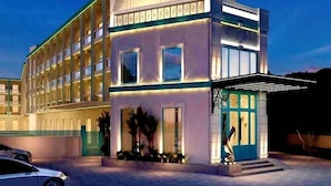 A modern hotel with a two-story structure, large windows, and a well-lit entrance. - Ramada by Wyndham Goa Arpora (Arpora)