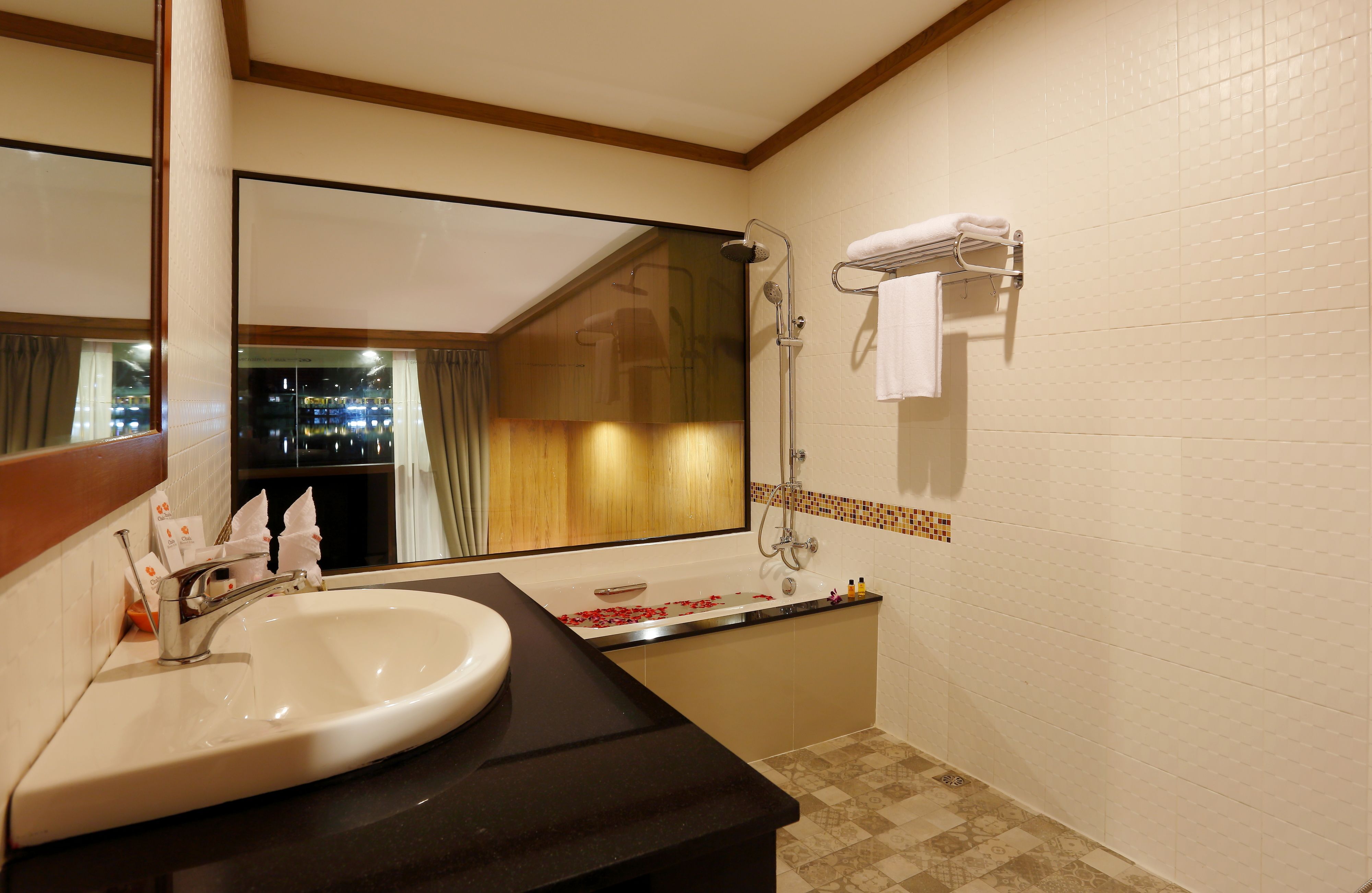 A bathroom with a sink, mirror, shower, and bathtub.