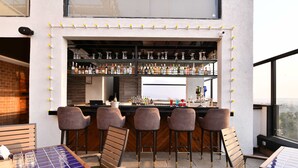 An outdoor bar area with multiple stools and a bar counter. - Krishna Palace Hotel Ambernath (Ambernath)