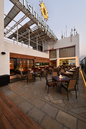 A rooftop bar area with outdoor seating and a bar.