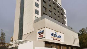 A modern building with a dining bar named 'Sudama' and a sign for 'Sudama Dining Bar'.