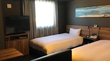 Habitación de hotel con dos camas, televisión, escritorio y un cuadro en la pared.