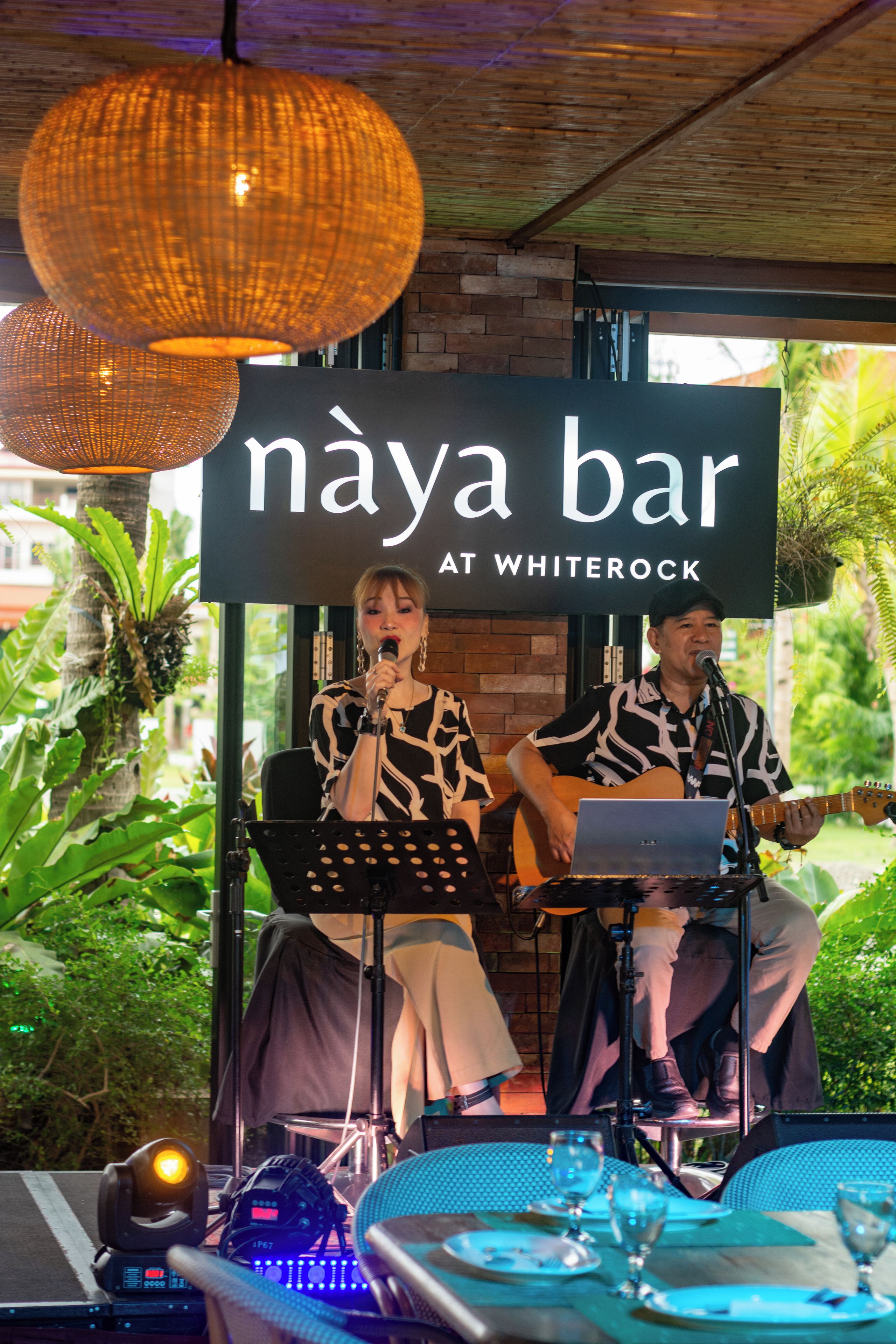 A stage with a sign reading 'naya bar at whiterock' and musical instruments.