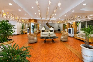 A spacious lobby with a central seating area, multiple sofas, and a staircase leading to upper floors. - Whiterock Beach Resort (Subic)