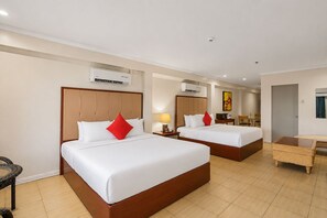 A hotel room with two beds, a desk, and a chair. - Whiterock Beach Resort (Subic)