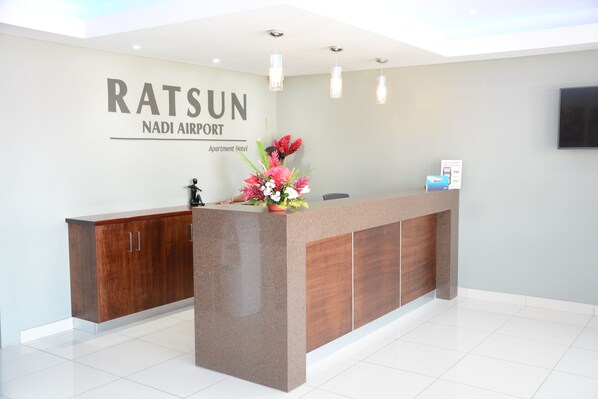 Ein Empfangstresen mit einem Schild, auf dem 'RATSUN NADI AIRPORT Apartment Hotel' steht.