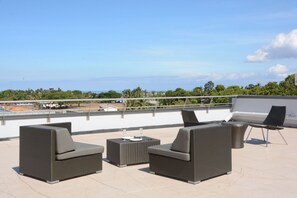 A rooftop terrace with outdoor furniture and a view of the ocean. - Ratsun Nadi Airport Apartment Hotel (Nadi)