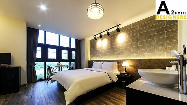 Habitación de hotel moderna con una cama grande, un escritorio y vistas al exterior a través de una ventana.