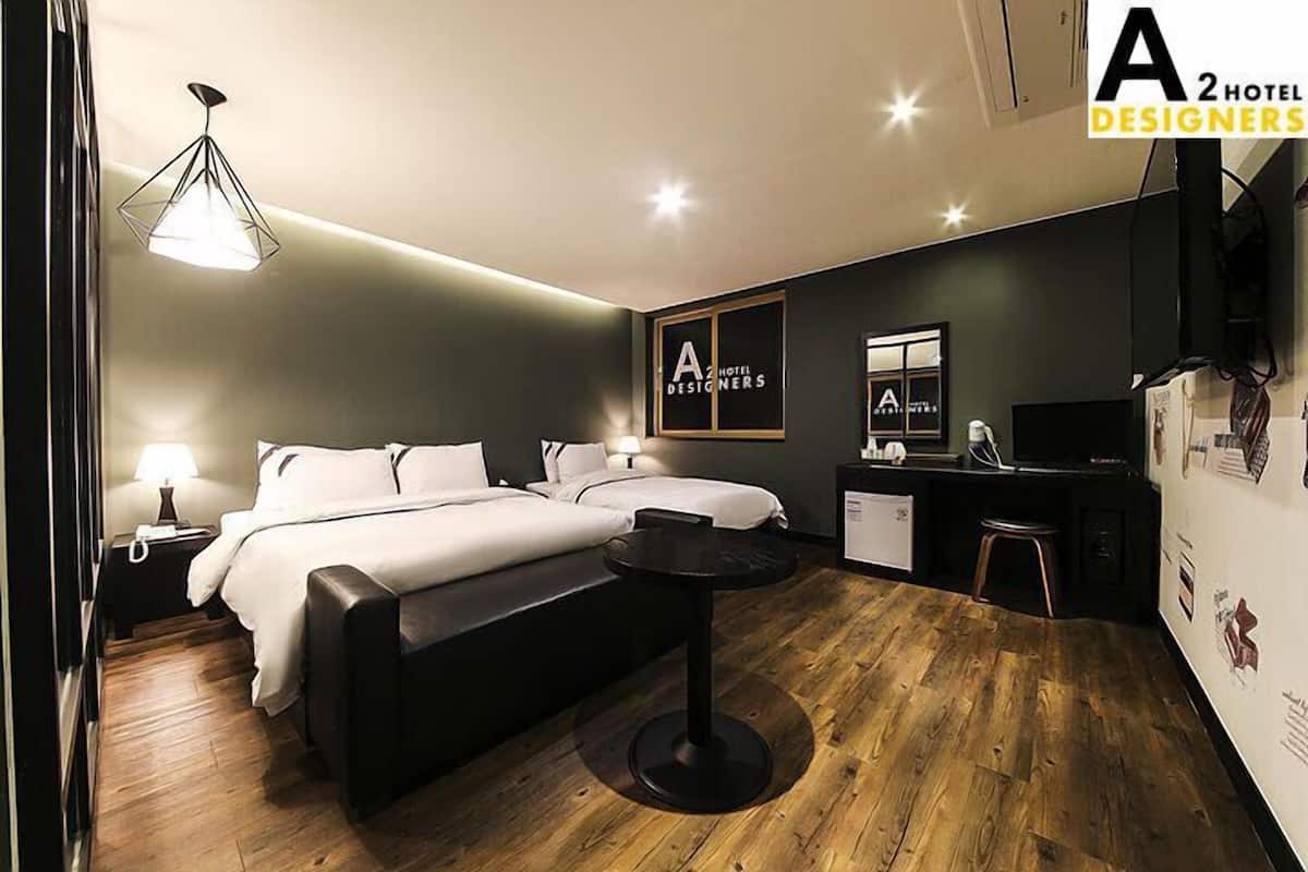 Una habitación de hotel moderna con cama, mesita de noche, lámpara y un escritorio con silla.