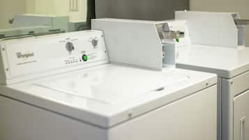 A Whirlpool washer with a control panel, a white countertop, and a mirror.