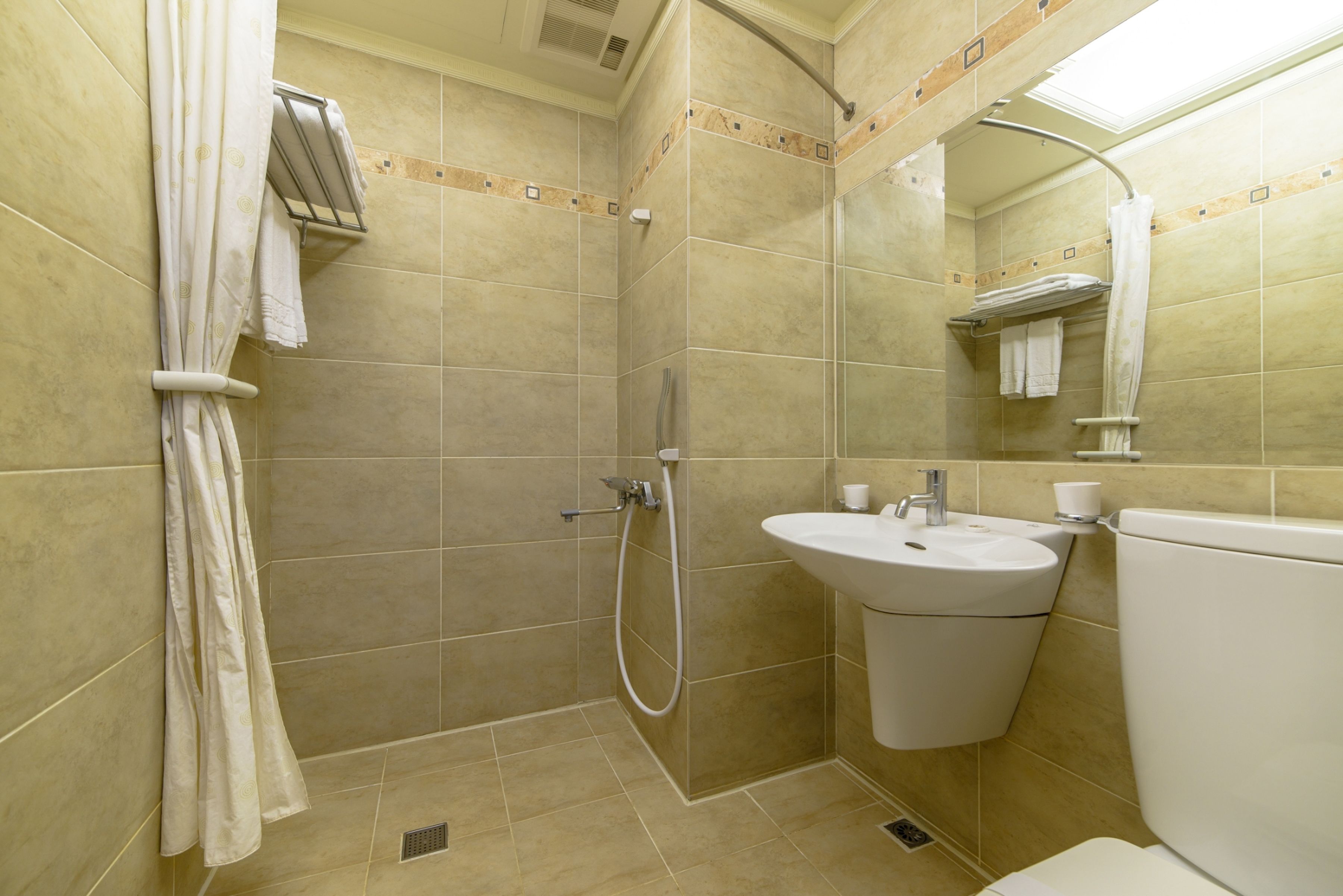 Un baño con ducha, lavamanos e inodoro.