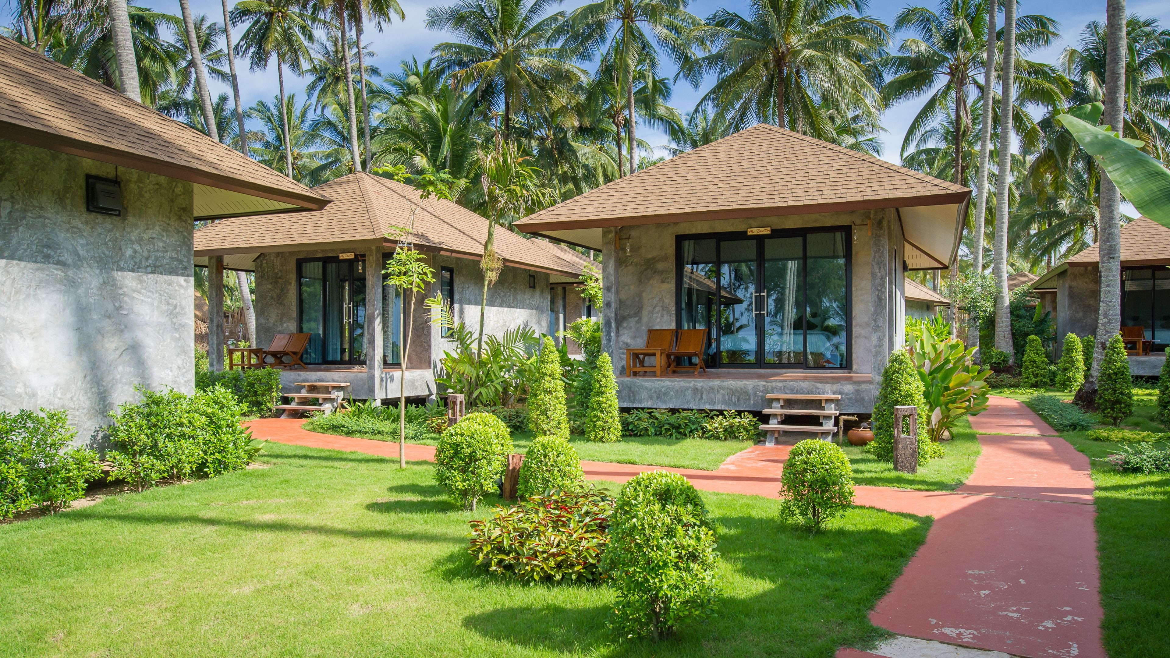 A resort with two-story buildings, each with a balcony and a seating area.