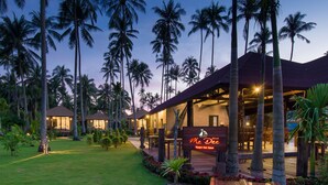 A resort with multiple buildings, palm trees, and a well-lit outdoor area. - Medee Resort (Ko Kood)