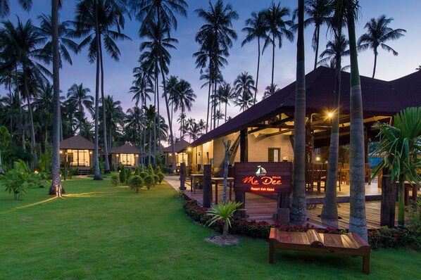 A resort with multiple buildings, palm trees, and a well-lit outdoor area. - Medee Resort (Ko Kood)