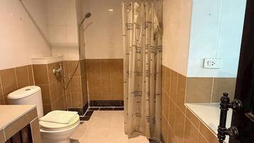 A bathroom with a toilet, shower, and bathtub.