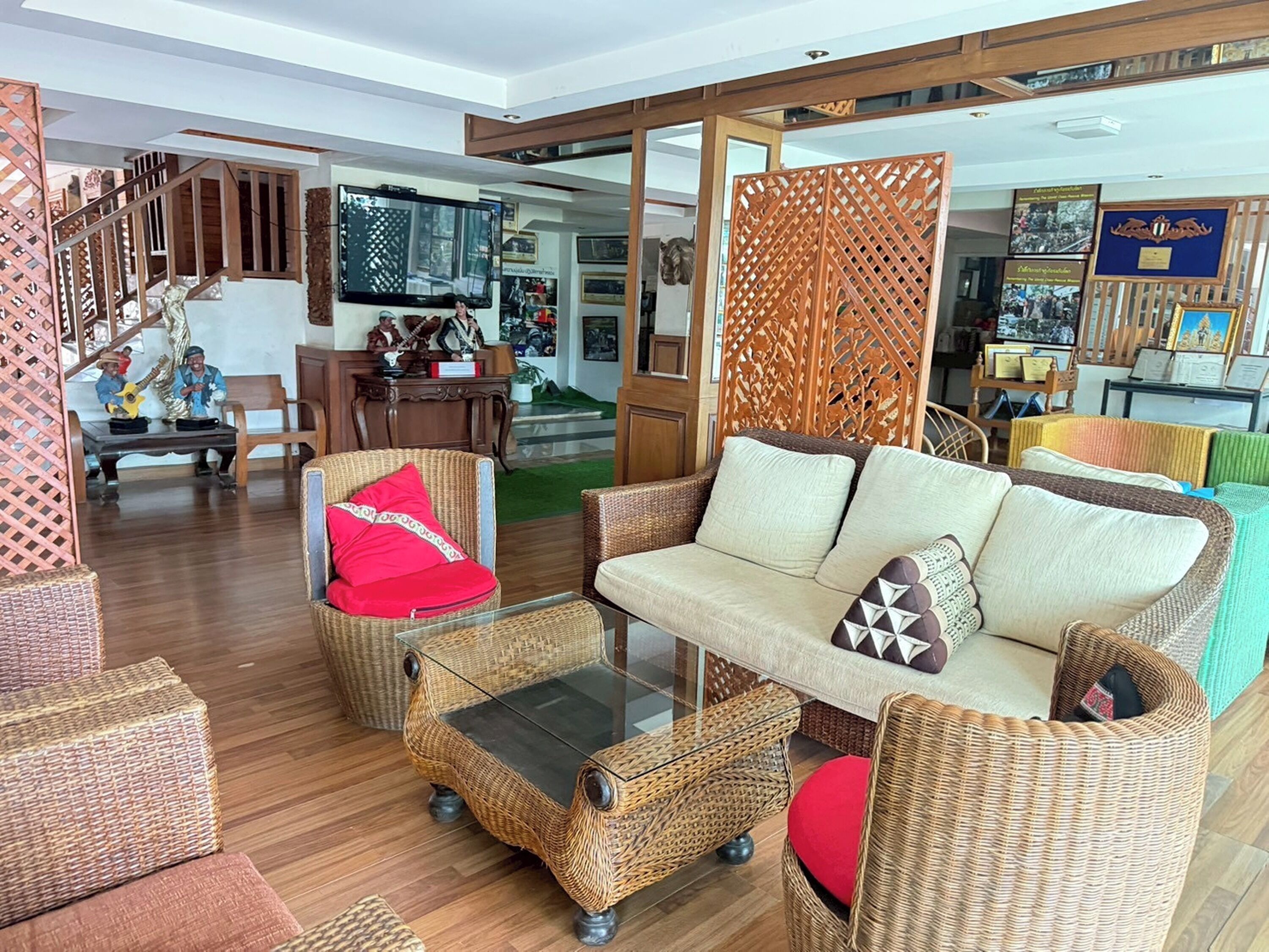 A spacious living area with wicker furniture, a sofa, and a glass coffee table.