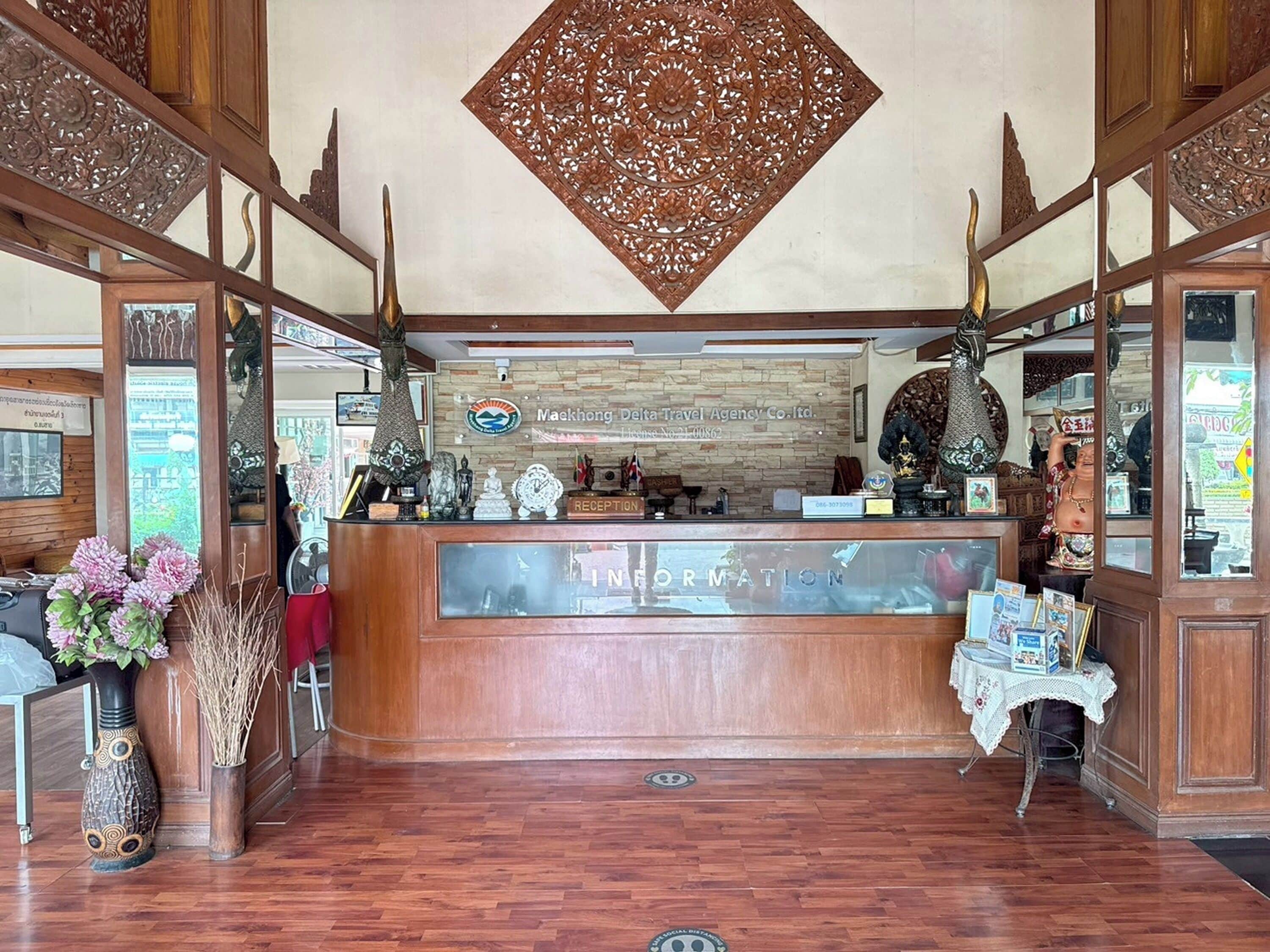 A reception desk with a wooden finish, a glass partition, and a decorative wall above.