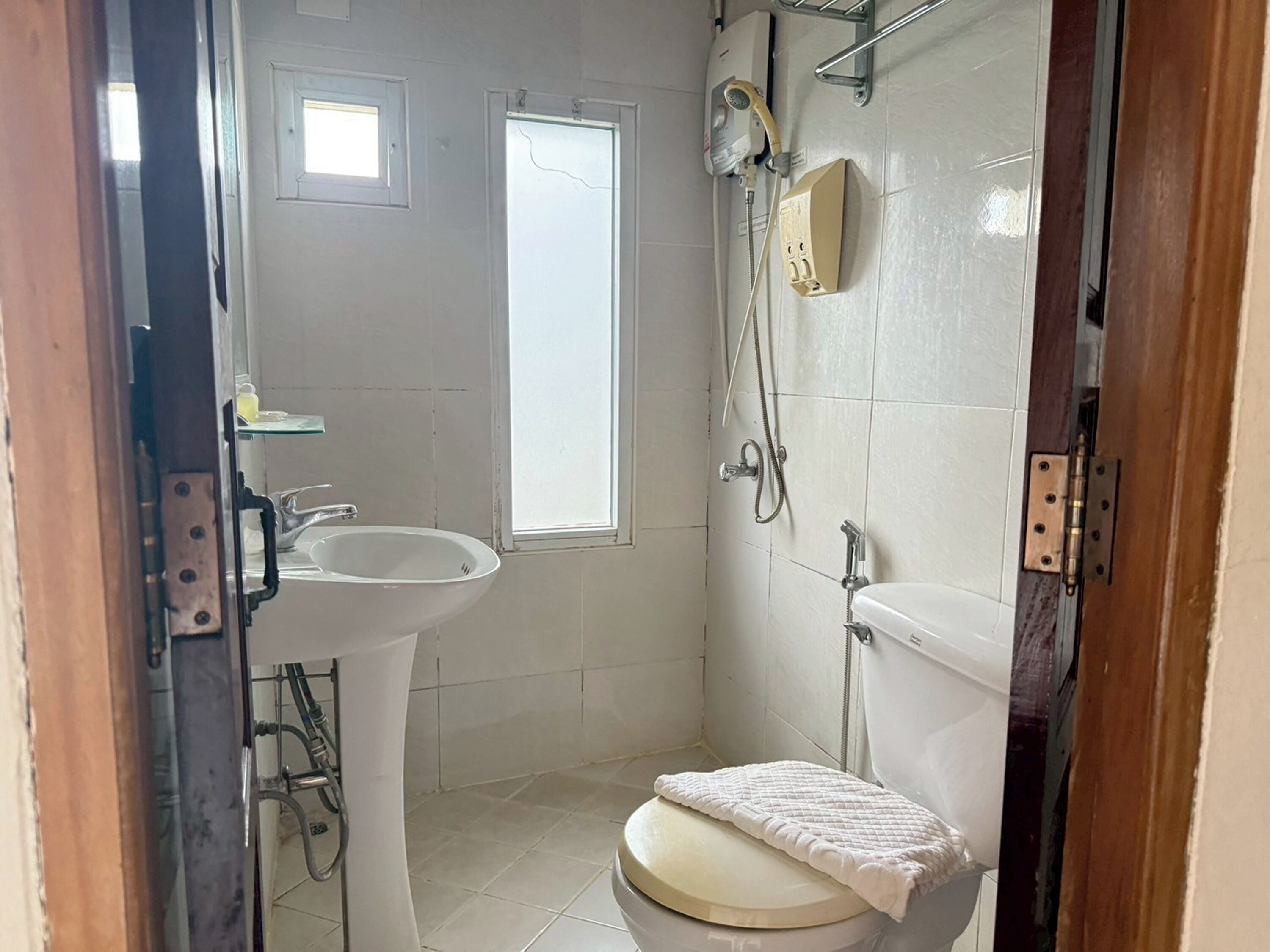 A small, clean bathroom with a toilet, sink, and shower.