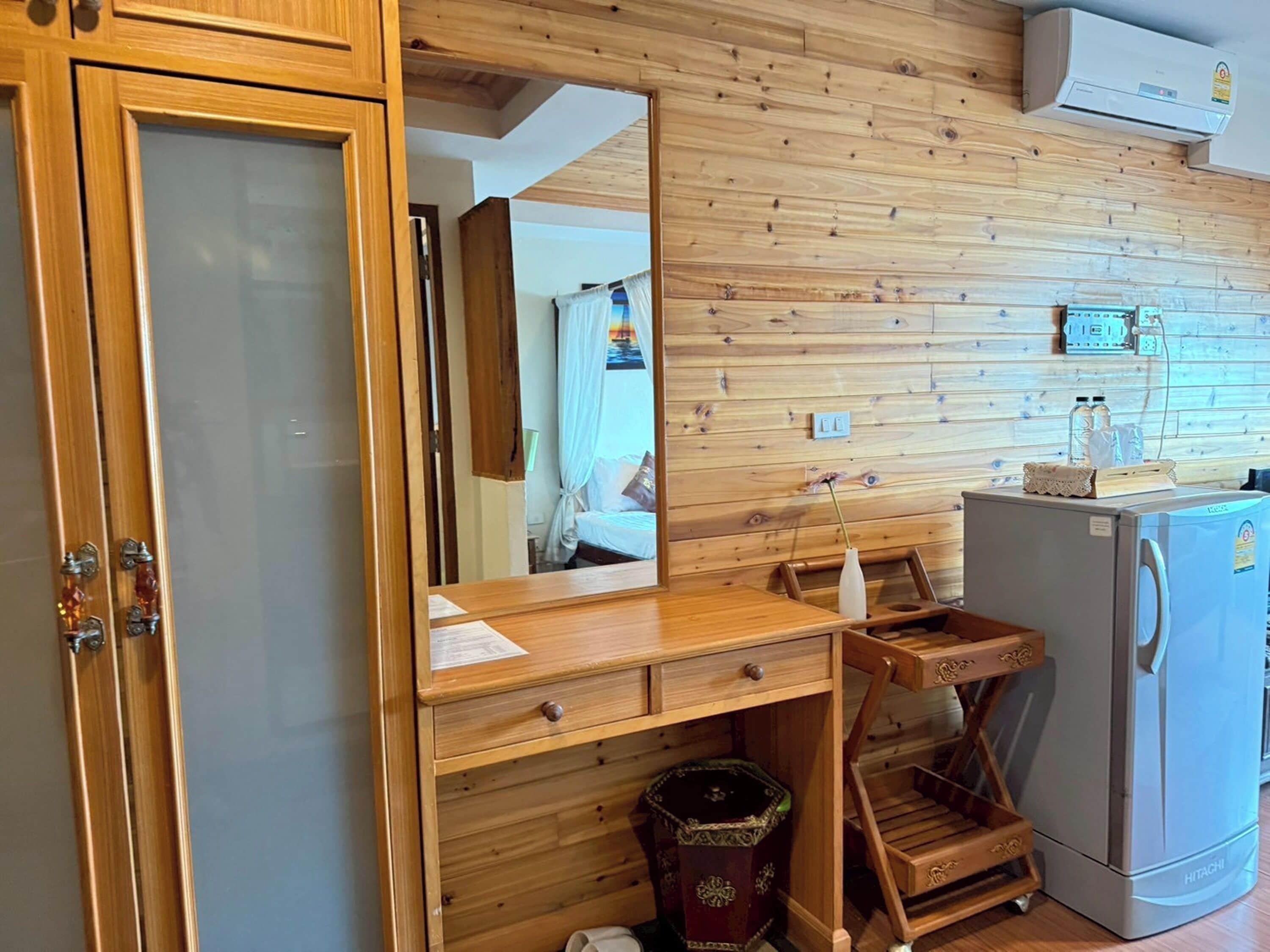 A compact kitchen with wooden cabinetry, a built-in stove, and a small refrigerator.