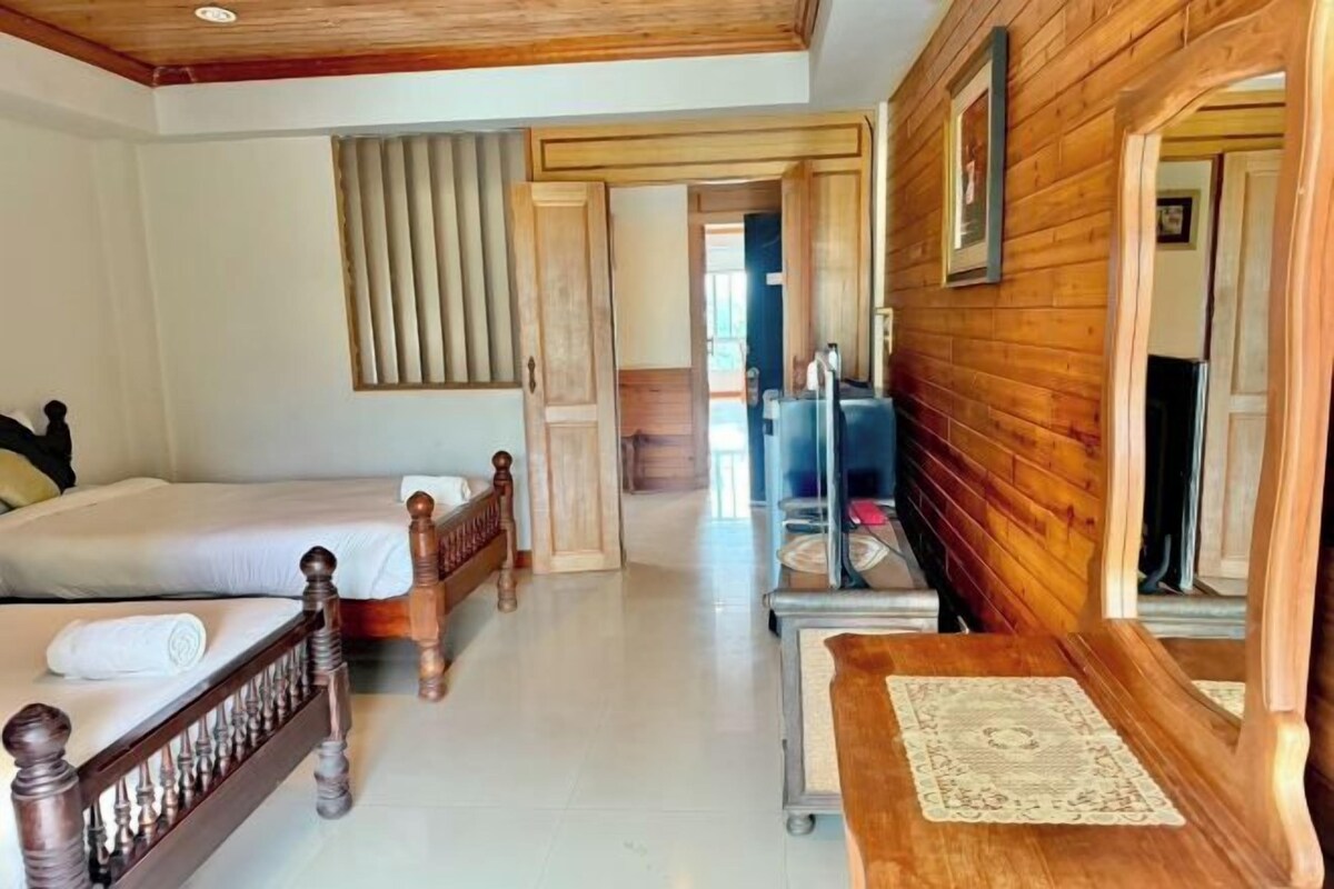 Un dormitorio con una cama de madera, una mesita de noche y un espejo.