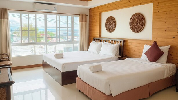 Habitación de hotel con dos camas, techo de madera y un ventanal con vistas al exterior.