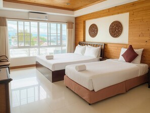 A hotel room with two beds, a wooden ceiling, and a large window offering a view of the outdoors. - Maekhong Delta Boutique Hotel (Mae Sai)