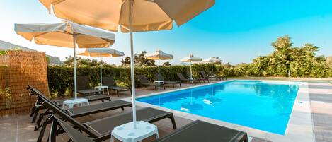 Piscine extérieure, parasols de plage, chaises longues