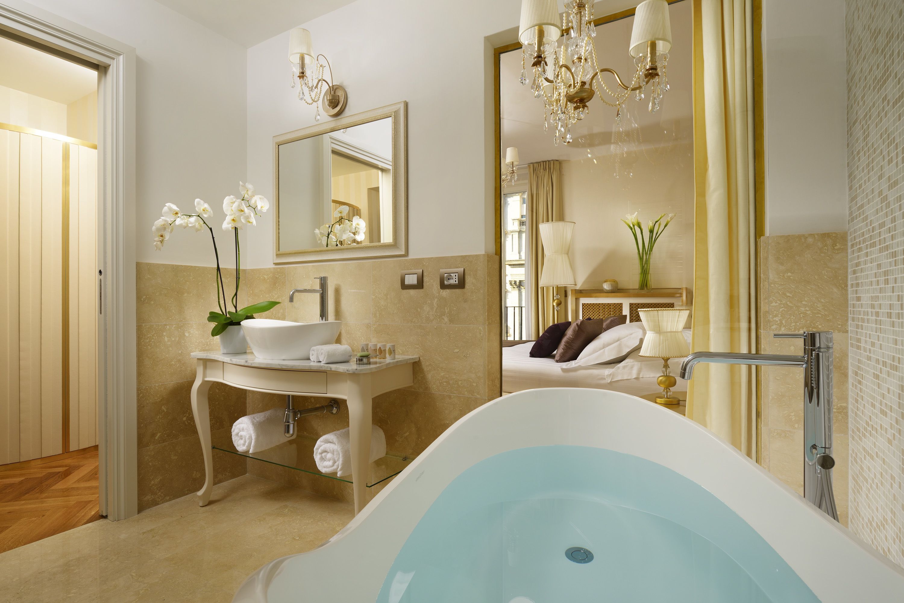 Ein modernes Badezimmer mit einer freistehenden Badewanne, einem Waschtisch mit Spiegel und einer Kandelaberleuchte.