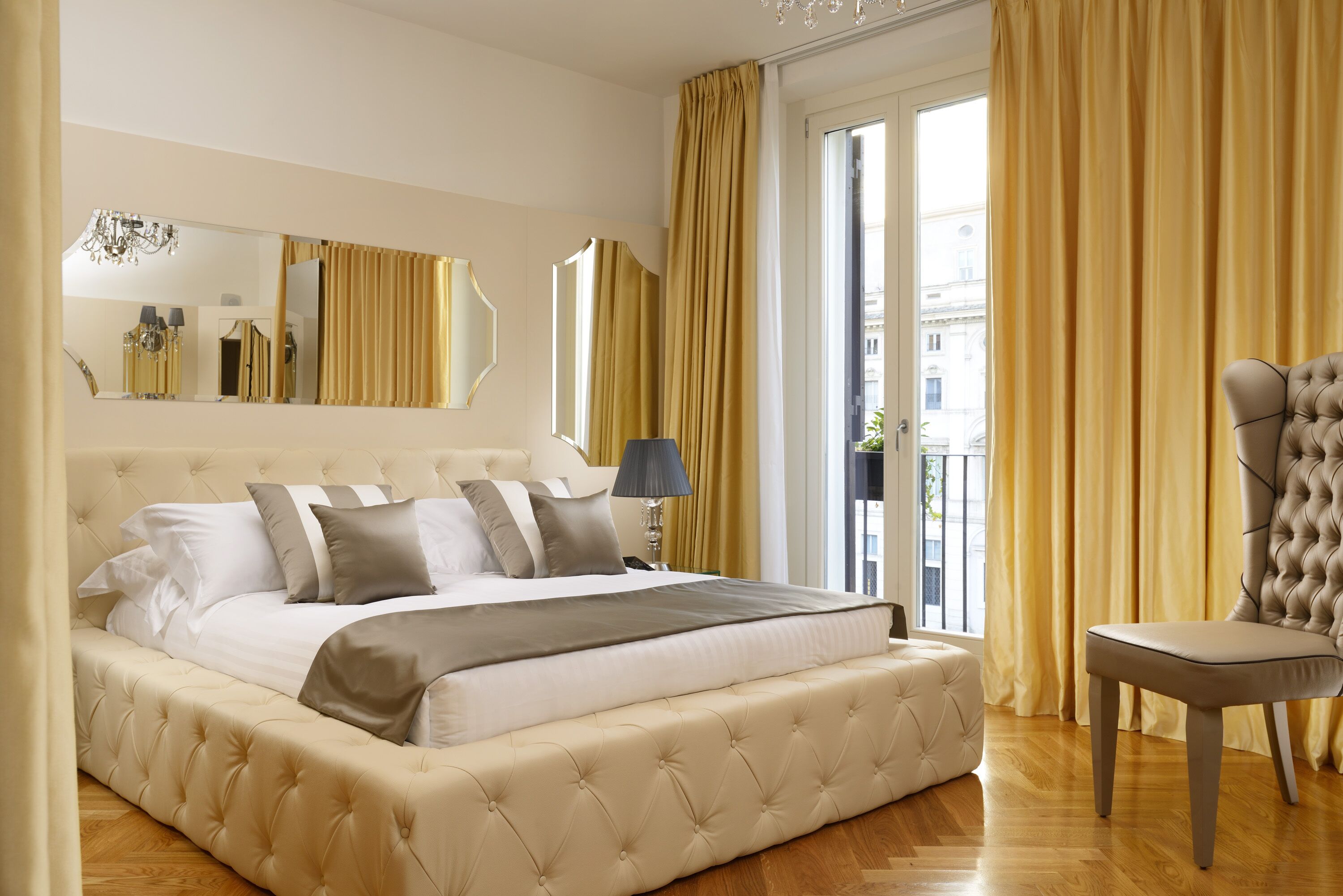 Un dormitorio amplio con una cama grande, una zona de estar y vistas a la ciudad desde la ventana.