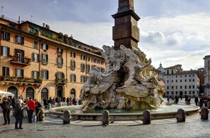 A historic fountain with classical sculptures, surrounded by traditional buildings and a cobblestone plaza. - Lifestyle Suites Rome (Rome)