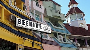 A hostel with a sign reading "BeeHive Phuket Old Town Hostel."