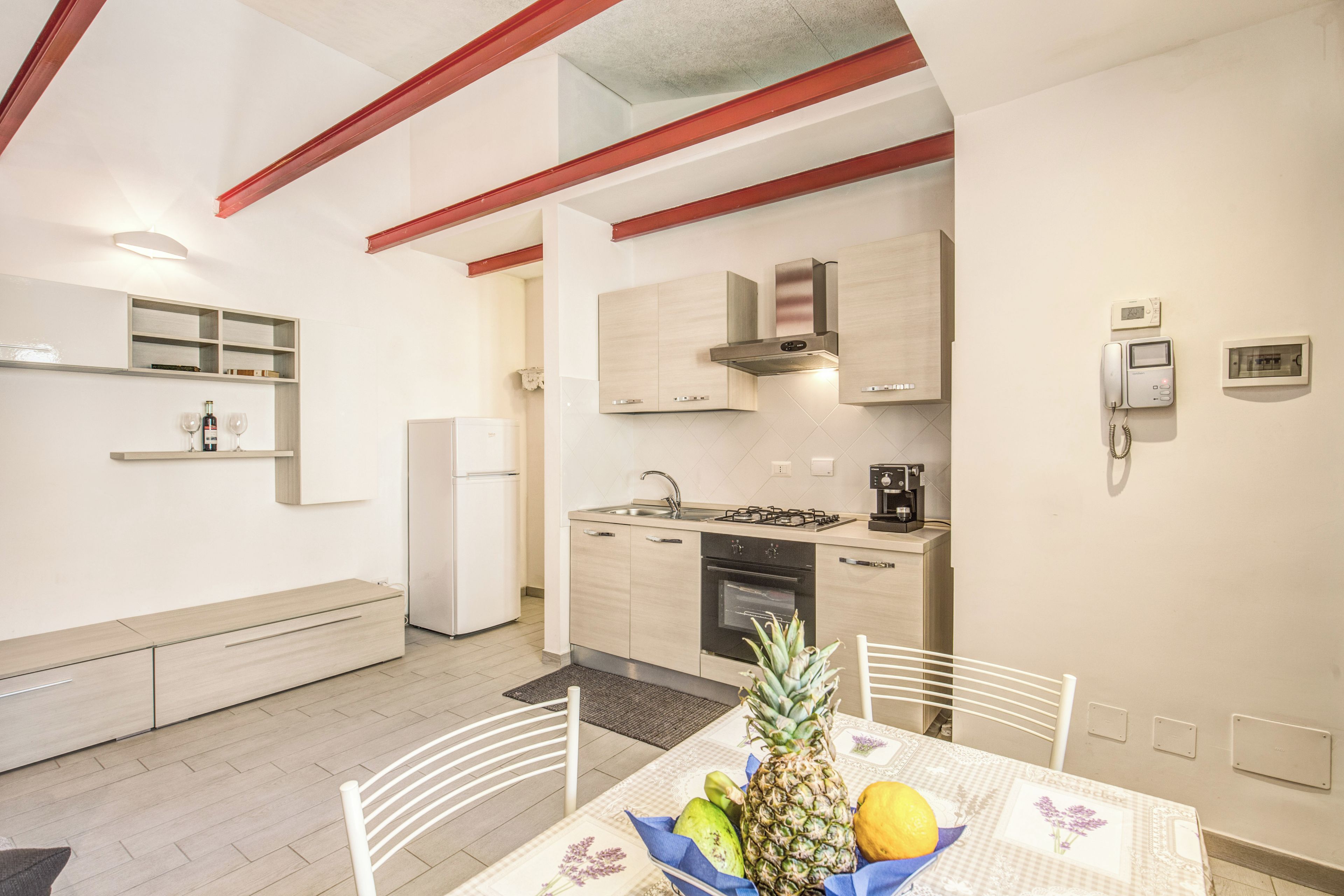 Una cocina compacta con electrodomésticos modernos, un comedor con una mesa para dos personas y un banco empotrado.