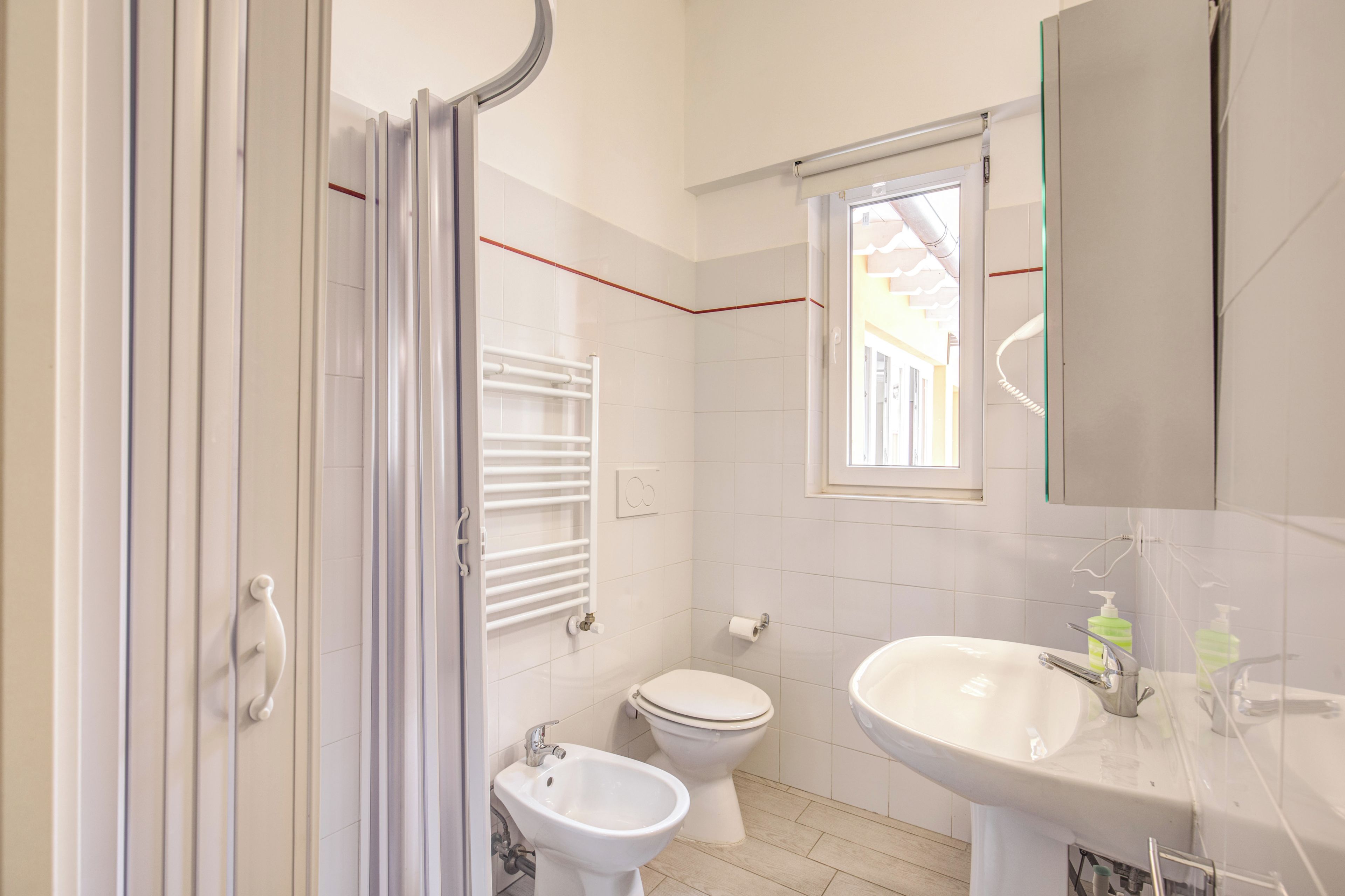 Een badkamer met douche, toilet, bidet en wastafel.
