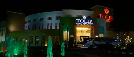 A hotel with a prominent sign reading "TOLIP FAMILY PARK HOTEL" and a large illuminated star decoration.
