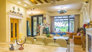 Ampla sala de estar com mesa de jantar, assentos confortáveis e vista para o exterior.