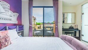 Quarto de hotel com uma cama, uma escrivaninha, uma cadeira e vista para o exterior.