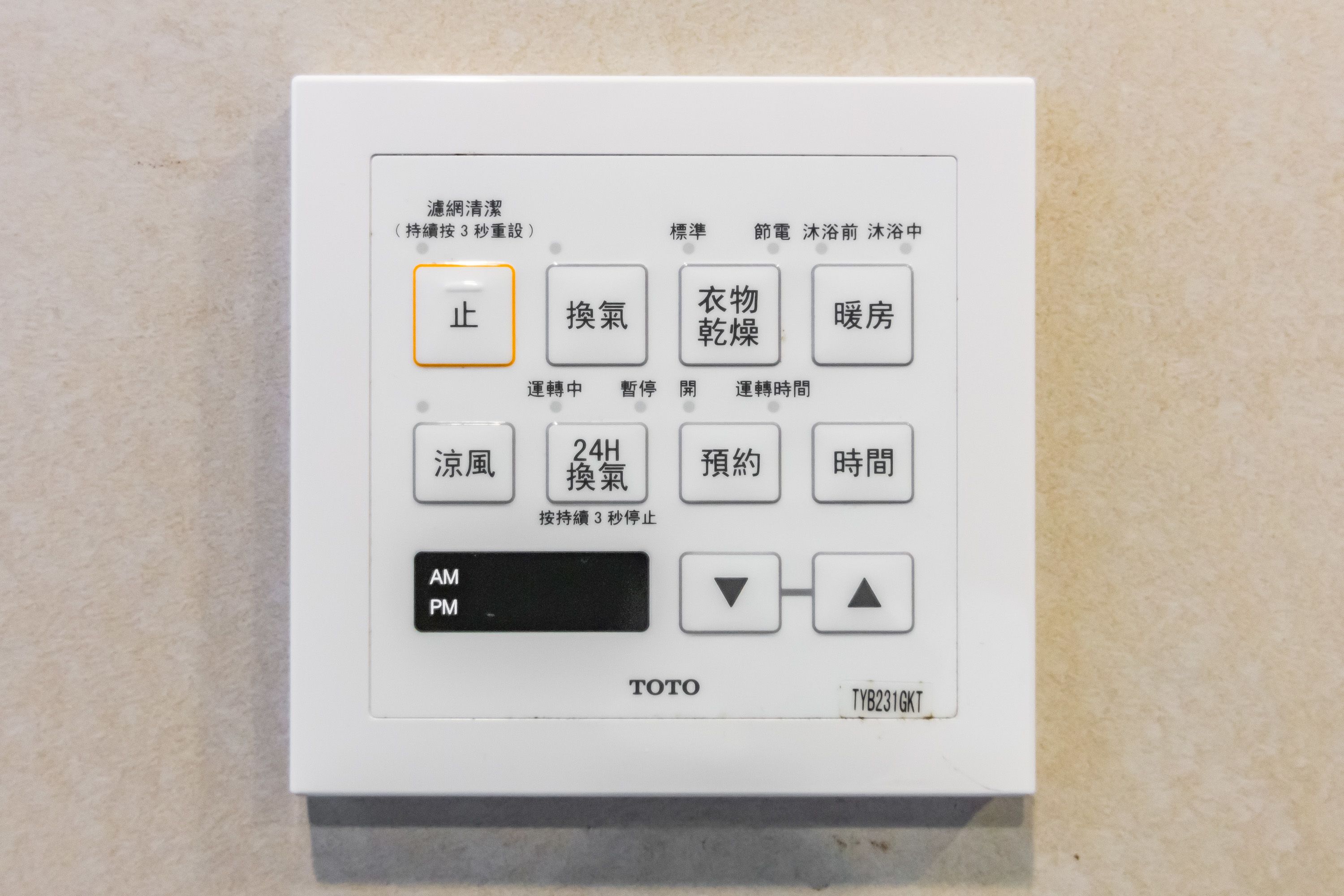A TOTO control panel with multiple buttons and a digital display.