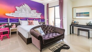 Quarto com cama, sofá estofado, piano e um mural na parede.