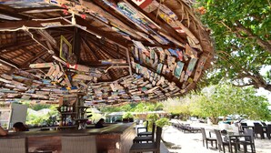 A wooden structure with a thatched roof, surrounded by outdoor seating and tables. - Reef Resort (Ko Kradan)