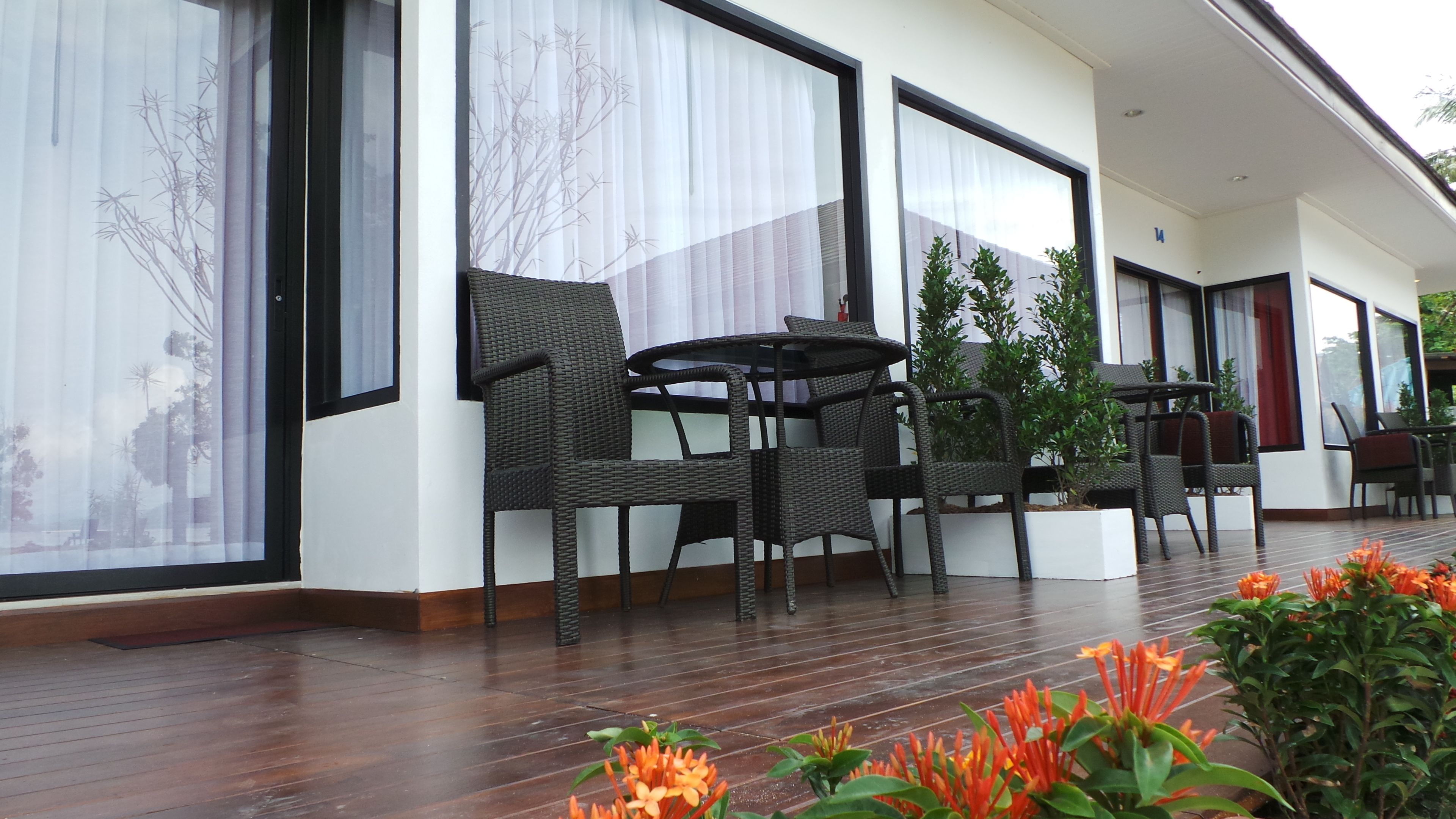 A modern outdoor seating area with wicker furniture and potted plants.