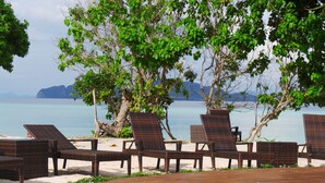 A beachside lounge with wicker chairs and a view of the sea and distant islands. - Reef Resort (Ko Kradan)