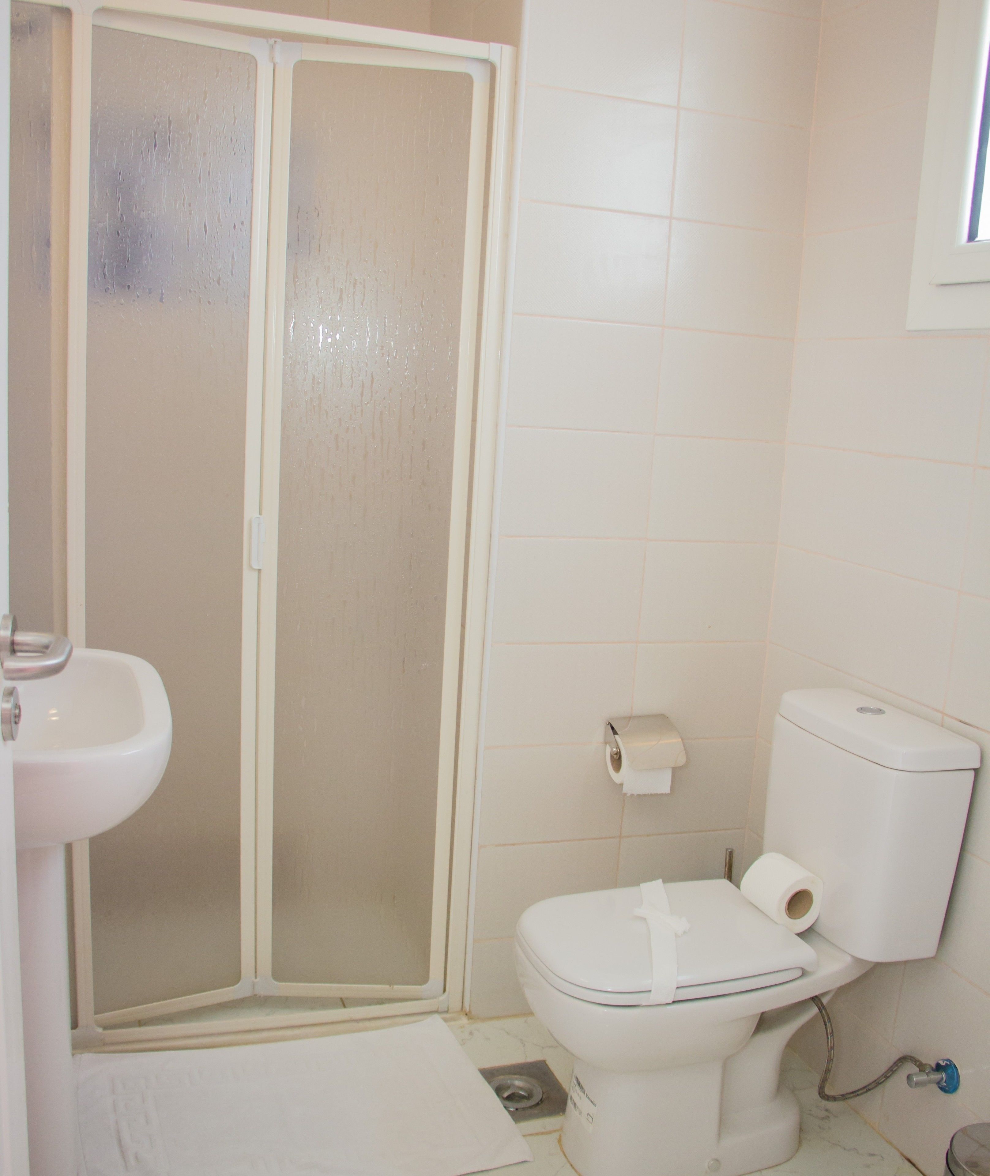 Une salle de bain équipée d’une douche, de toilettes et d’un lavabo.