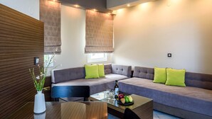 Ein modernes Wohnzimmer mit einem Ecksofa, einem Glastisch und einem kleinen Beistelltisch.