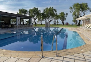 Outdoor pool, an infinity pool, pool umbrellas, pool loungers