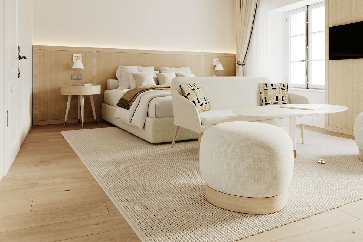 Une chambre moderne avec un lit, un canapé, une petite table et un téléviseur.