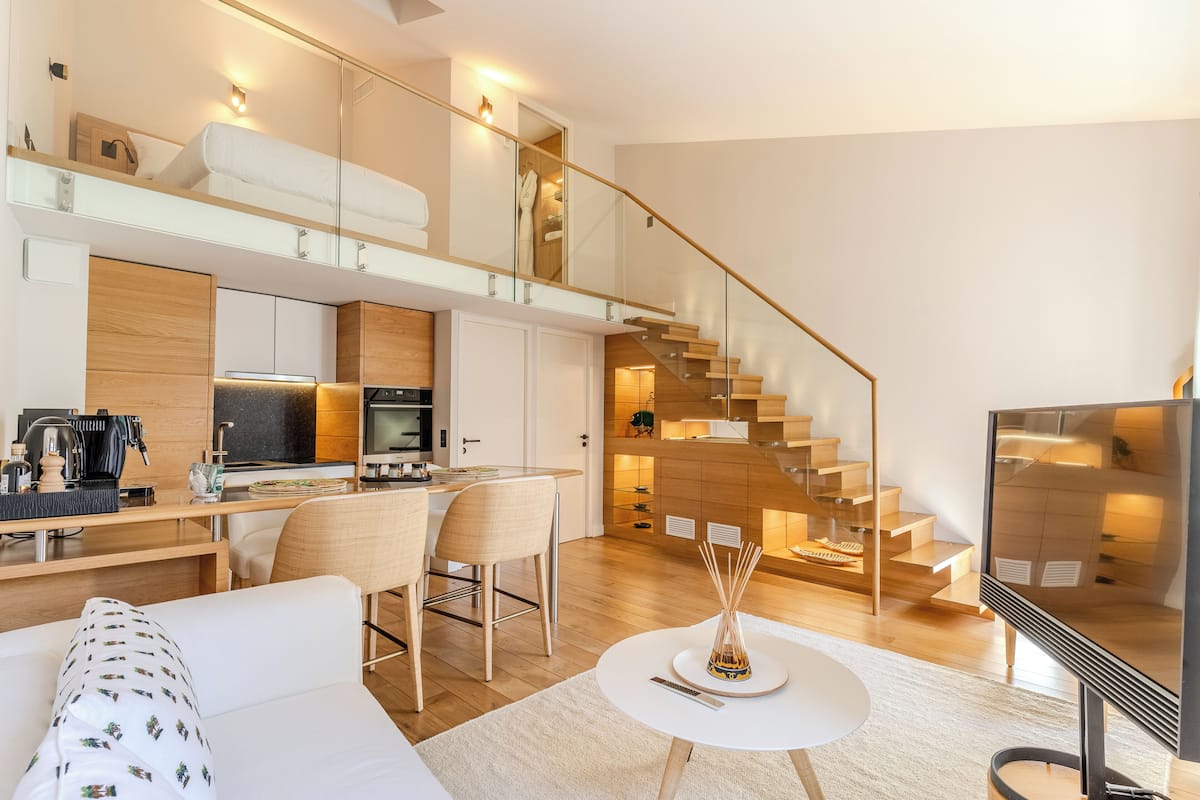 Un appartement moderne doté d’une cuisine, d’un coin repas et d’un escalier.