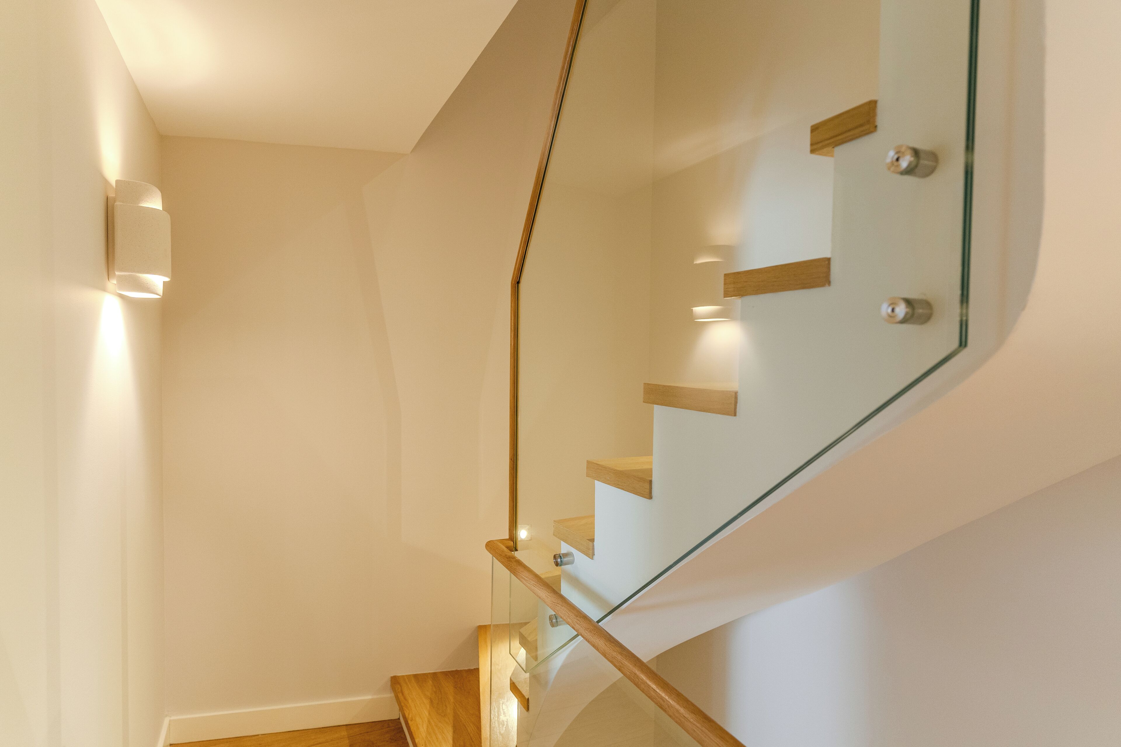 Un escalier moderne avec des rampes en verre et des marches en bois.