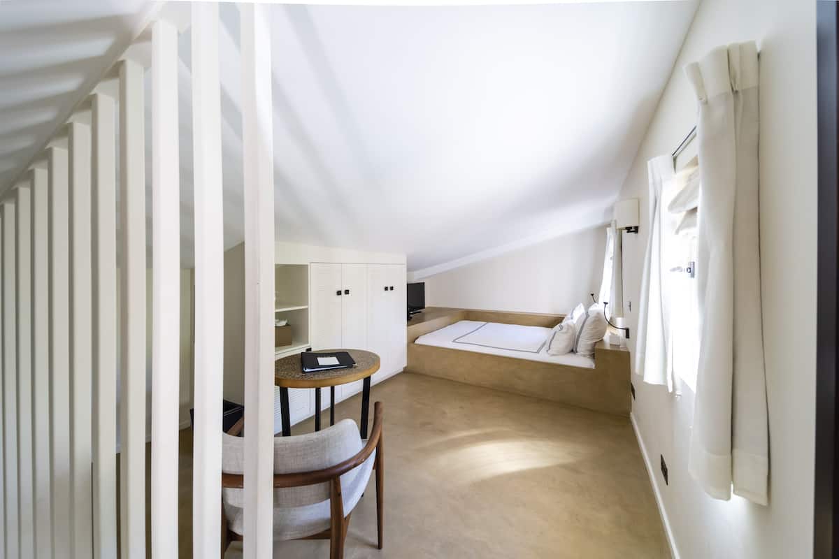 Une petite pièce confortable, avec un lit, une table et une chaise.