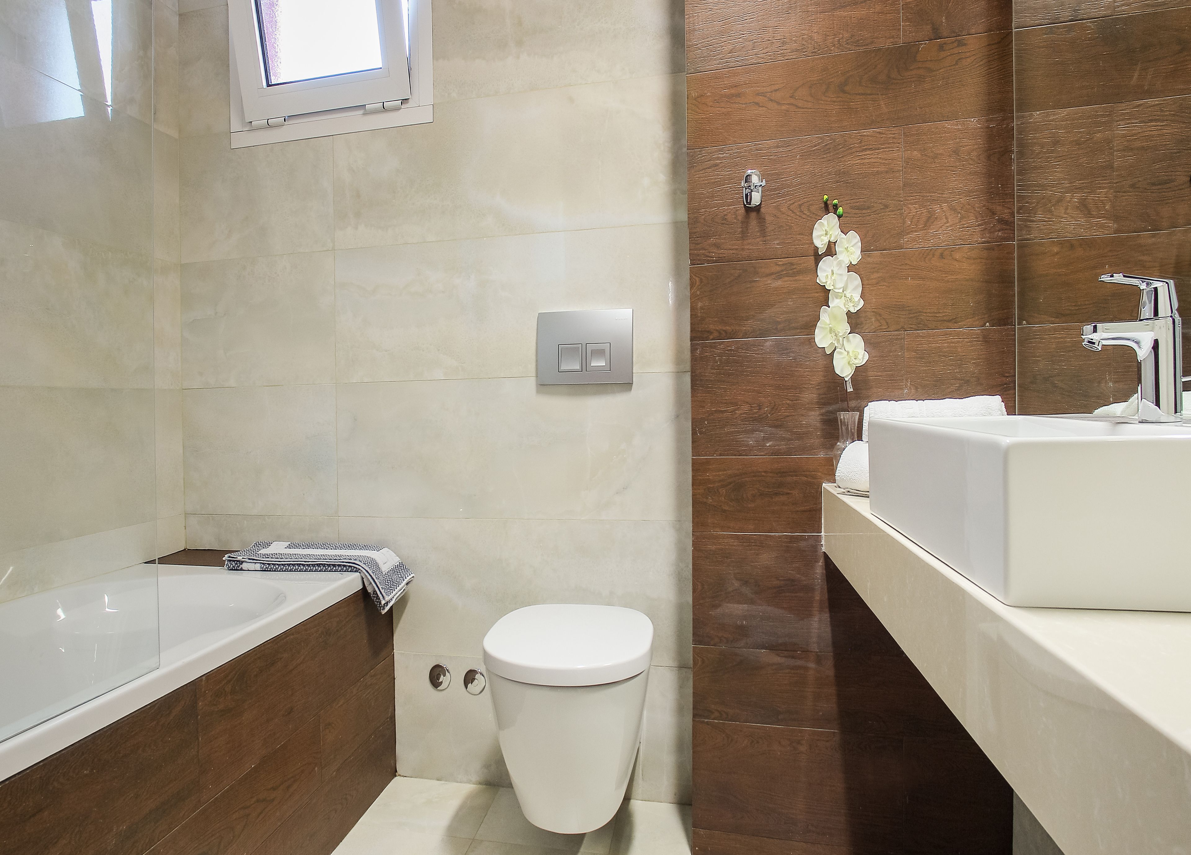A modern bathroom with a bathtub, toilet, and sink.