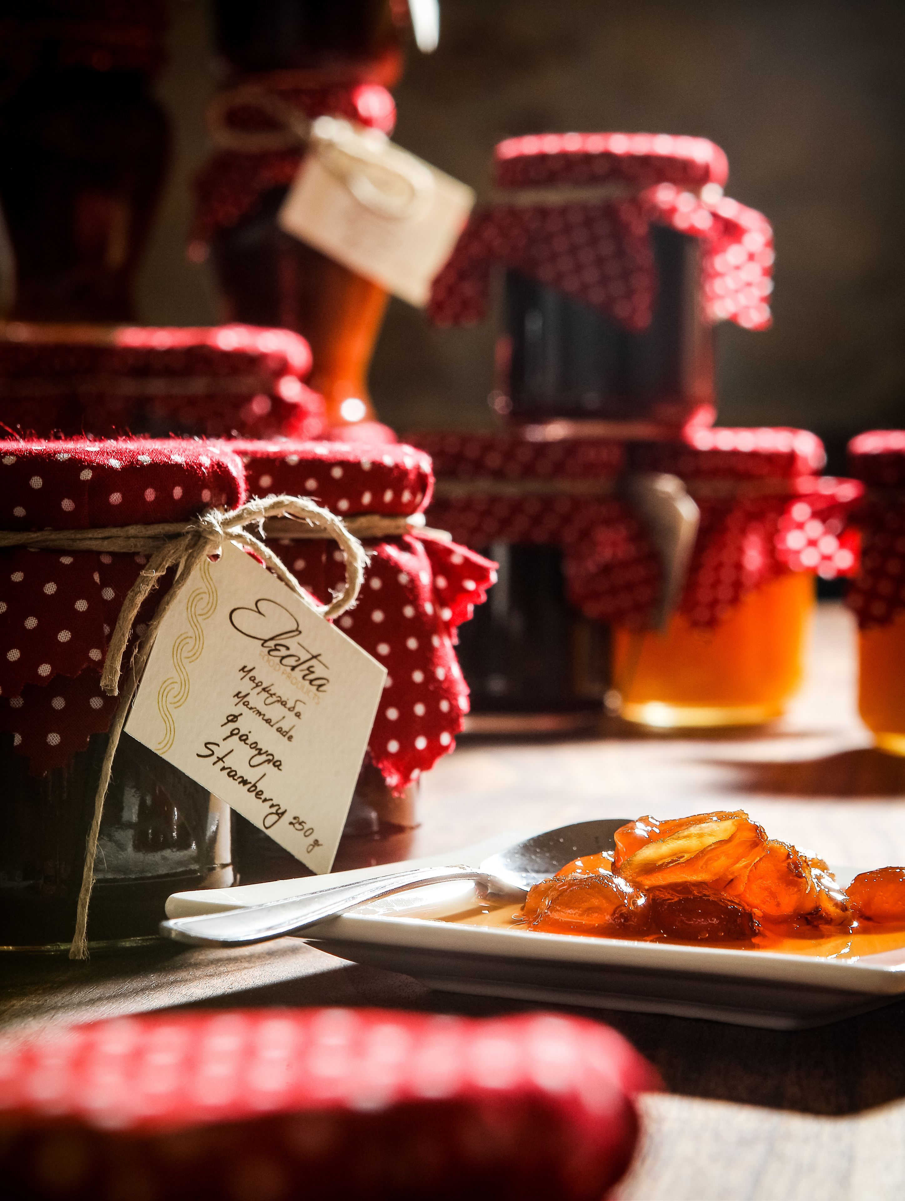 A table with jars of jam and a plate of food.